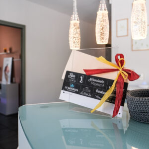 Bon cadeau spa Le Naturspa avec nœud décoratif, posé sur une table dans un intérieur cosy